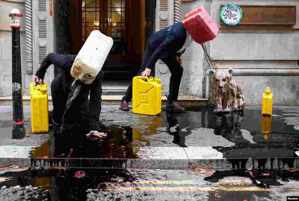 Activists from the climate action group Ocean Rebellion perform outside The Baltic Exchange building, in London, Britain.