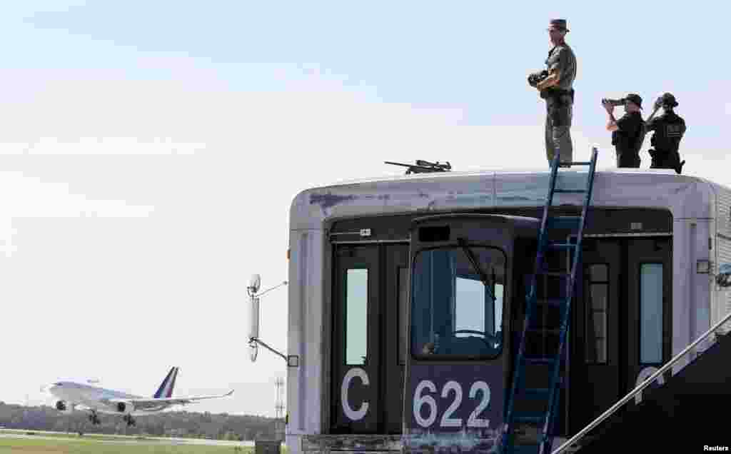 Security personnel watch as the airplane carrying French President Francois Hollande and his companion Valerie Trierweiler arrives for the G8 Summit at Dulles International Airport in Chantilly May 18, 2012.