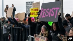 Demonstran berkumpul di bandara internasional John F. Kennedy di New York, Sabtu, 28 Januari 2017 setelah dua pengungsi Irak ditahan ketika mencoba masuk Amerika. Presiden Trump hari Jumat, 27 Januari, menandatangani keputusan melarang kedatangan orang-orang dari negara-negara terlibat terorisme selama 90 hari. 