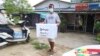Seorang relawan dari Komisi Pemilihan Umum (Union Election Commission) membawa kotak suara untuk mengumpulkan surat suara dari para lansia di pinggiran Kota Yangon, Myanmar, Kamis, 29 Oktober 2020.
