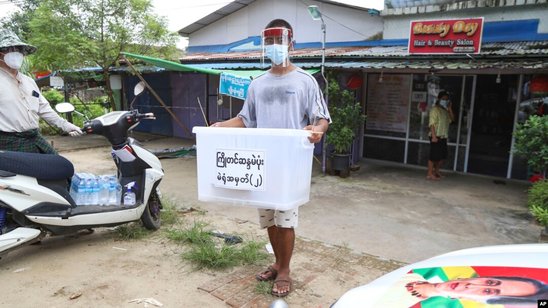 Seorang relawan dari Komisi Pemilihan Umum (Union Election Commission) membawa kotak suara untuk mengumpulkan surat suara dari para lansia di pinggiran Kota Yangon, Myanmar, Kamis, 29 Oktober 2020.