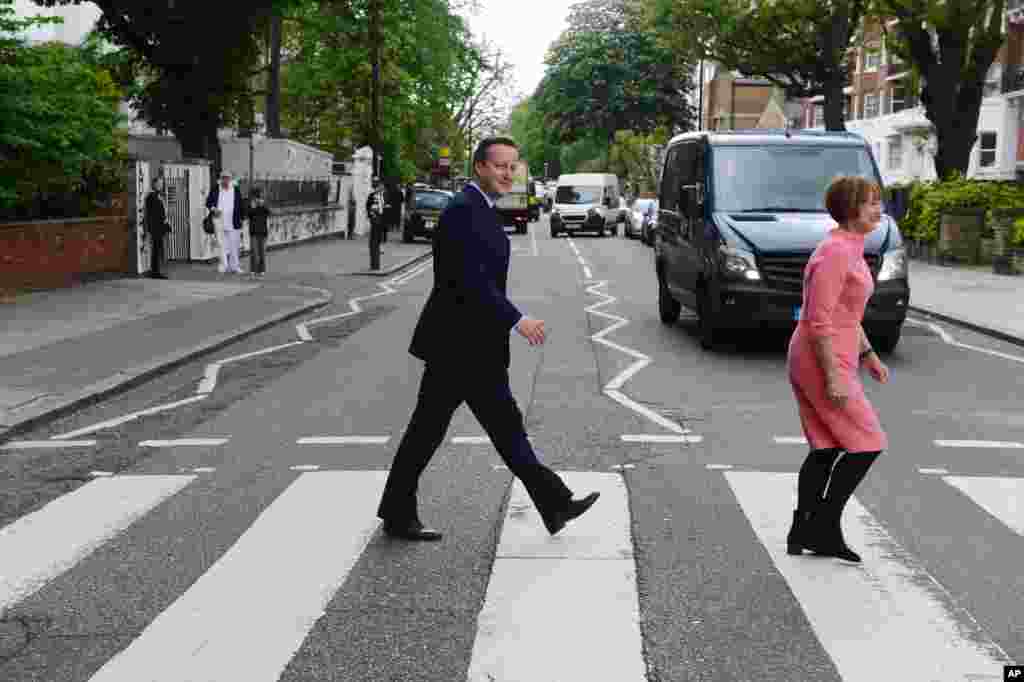 Prime Minister David Cameron with former Culture Secretary Tessa Jowell try to recreate for the media the famous Beatles album cover during their visit to Abbey Road recording studios in north London where they met with representatives of the creative industries to discuss a letter that called for the Britain to remain in the EU .