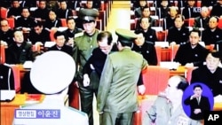 Imágenes de la televisión norcorena muestran al tío Jang siendo escoltado por uniformados de una reunión del politburó del Partido de los Trabajadores.