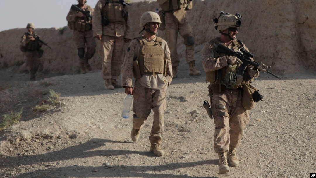 FILE - A U.S. Marine patrols a village while on a joint mission with Afghan National Army soldiers to clear the town of Taliban insurgents in the Helmand province of Afghanistan, Aug. 13, 2009. 