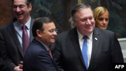 FILE - U.S. Secretary of State Mike Pompeo, left, shakes hands with the foreign minister of Peru Nestor Popolizio Bardales at the United Nations Security Council during a meeting on North Korea, at the United Nations in New York, Sept. 27, 2018. 