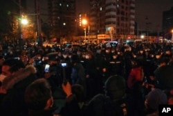 Protesters clash with policemen during a protest in Beijing, Sunday, Nov. 27, 2022. (AP Photo/Andy Wong)