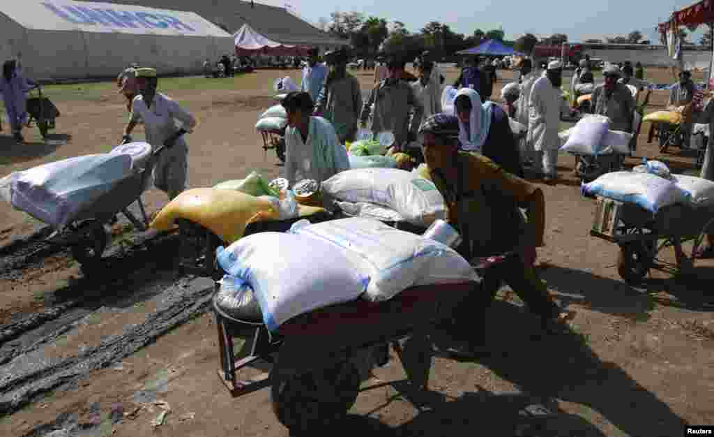 Des gens qui ont fui l&#39;offensive militaire contre les militants pakistanais dans le Waziristan du Nord, repartent avec des brouettes de documents de secours après avoir reçu une tente de stockage du Programme alimentaire mondial (PAM) à un point de distribution pour déplacés. 