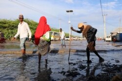 Somalis wade through floodwaters after heavy rain in Mogadishu, Somalia, Oct. 21, 2019.