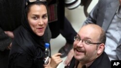 FILE - Jason Rezaian, an Iranian-American correspondent for The Washington Post, and his wife Yeganeh Salehi, an Iranian correspondent for Abu Dhabi-based newspaper The National, attend a presidential campaign of President Hassan Rouhani in Tehran, April 11, 2013. 