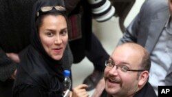 FILE - Jason Rezaian, right, an Iranian-American correspondent for The Washington Post, and his wife, Yeganeh Salehi, an Iranian correspondent for the Abu Dhabi-based newspaper The National, attend a presidential campaign of President Hassan Rouhani in Tehran, Iran.