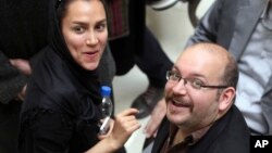 File - Jason Rezaian (R), an Iranian-American correspondent for The Washington Post, and his wife Yeganeh Salehi, an Iranian correspondent for the Abu Dhabi-based The National, attend a presidential campaign of President Hassan Rouhani in Tehran, Iran.