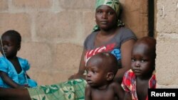 FILE - A mother sits with her children in Wurojuli, Gombe State, Nigeria, Sept. 2, 2014. Africa's children may account for nearly half of the world’s poor by 2030, a report by the Overseas Development Institute says.