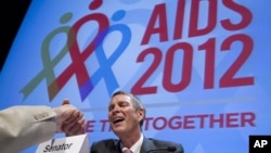 Former Senate Majority Leader Bill Frist shakes hands with a member of the audience at the XIX International AIDS Conference in Washington, July 25, 2012. 