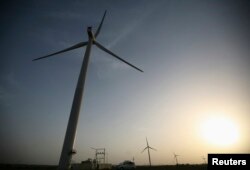 FILE - Power-generating windmill turbines are pictured during the inauguration ceremony of the 25-megawatt ReNew Power wind farm at Kalasar village in the western Indian state of Gujarat, May 6, 2012.