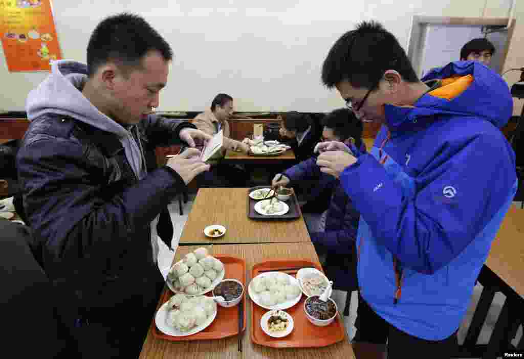 Diners take pictures of similar steamed buns that Chinese President Xi Jinping ate at the Qing-Feng steamed buns restaurant in Beijing. Xi showed off the common touch on Dec. 28, 2013, with a surprise visit to a steamed bun restaurant in Beijing where he paid for his food and happily chatted to surprised customers.