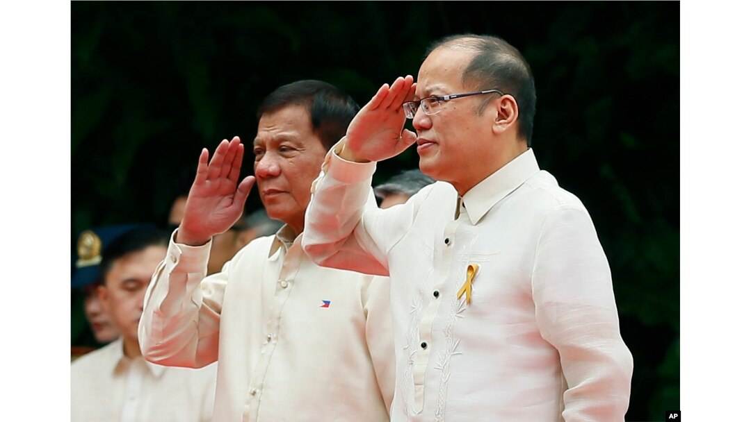 New Philippine President Rodrigo Duterte, left, and outgoing President Benigno Aquino III salute during inauguration ceremony Thursday, June 30, 2016.