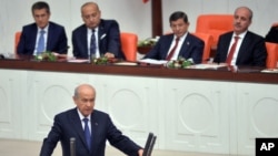 Prime Minister Ahmet Davutoglu (2nd R) and his ministers listen as lawmakers are sworn into office during a ceremony in Ankara, Turkey, June 23, 2015, in an early step in what could be a drawn-out coalition-building process.