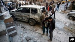 23일 예멘 사나의 시아파 후티 반군이 폭탄 테러로 파괴된 자동차 주변에 서 있다.