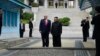 Presiden AS Donald Trump dan pemimpin Korea Utara Kim Jong Un berdiri di wilayah Korea Utara di zona demiliterisasi (DMZ), hari Minggu (30/6). 