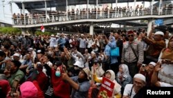 FILE - People protest outside Indonesia's Election Supervisory Board (Bawaslu) headquarters in Jakarta, Indonesia, May 10, 2019. 