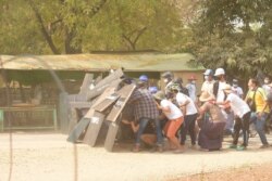Protesters take cover behind shields in Nyaung-U, Myanmar, March 7, 2021, in this still image from a video obtained from social media.