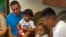 In this image taken from video, Javier Garrido Martinez, left, and Alan Garcia, right, sit with their 4-year-sons at a news conference in New York, July 11, 2018. They men were reunited with their children after almost two months of separation. Authorities took their boys from them when they stopped at the U.S. southern border.