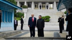 Perezida w'Amerika Donald Trump ari kumwe n'indongozi ya Koreya ya Ruguru Kim Jong UN ku rubibe Koreya zompi Zihana, itwariki 30/06/2019 