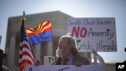 Charles Balogh demonstrates in front of the Supreme Court in Washington as the court holds a hearing on Arizona's "show me your papers" immigration law, April 25, 2012.