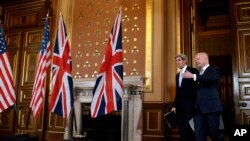 Menlu AS John Kerry (kiri) tiba di Konferensi Pers bersama Menlu Inggris William Hague dalam lawatan Kerry di London (25/2). (AP/Jacquelyn Martin)