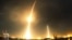 FILE - A long exposure photograph shows the SpaceX Falcon 9 lifting off (L) from its launch pad and then returning to a landing zone (R) at the Cape Canaveral Air Force Station.