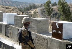 FILE - A Pakistani soldier stands guard at a newly erected fence between Pakistan and Afghanistan at Angore Adda, Pakistan, Oct. 18, 2017.