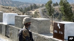 FILE - A Pakistani soldier stands guard at a newly erected fence between Pakistan and Afghanistan at Angore Adda, Pakistan, Oct. 18, 2017.