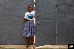 FILE—Mawufemor Vitor, a beneficiary under Uniti Networks, poses for a photograph in Hohoe, Ghana, April 18, 2024. Vitor, a church secretary, said a health app on Uniti's platform, has assisted her to track her menstruation to help prevent pregnancy.