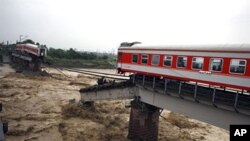 The two ends of a train remain on a bridge after passengers were evacuated near Guanghan in southwest China's Sichuan province, one of the areas hit hard by flooding , 19 Aug 2010