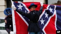 A Mississippi Highway Safety Patrol honor guard folds the retired Mississippi state flag after it was raised over the Capitol grounds one final time in Jackson, Miss., on July 1, 2020.