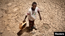 지난 15일 아프리카 소말리랜드 수도 하르게이사에서 한 소년이 물통을 들고 가뭄으로 갈라진 땅을 걷고 있다.