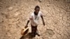 FILE - A boy carries a jerrycan in the drought-hit Baligubadle village near Hargeisa, the capital city of Somaliland, in this handout photo provided by The International Federation of Red Cross and Red Crescent Societies, March 15, 2017. 