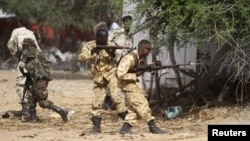 Somali government soldiers open fire during an ambush by al-Shabab rebels on the outskirts of Elasha town, Somalia, May 29, 2012.