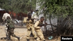 Somali government soldiers open fire during an ambush by al-Shabab rebels on the outskirts of Elasha town, Somalia, May 29, 2012.