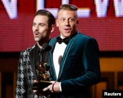 Macklemore & Ryan Lewis (L) win the award for Best New Artist at the 56th annual Grammy Awards in Los Angeles, California Jan. 26, 2014.