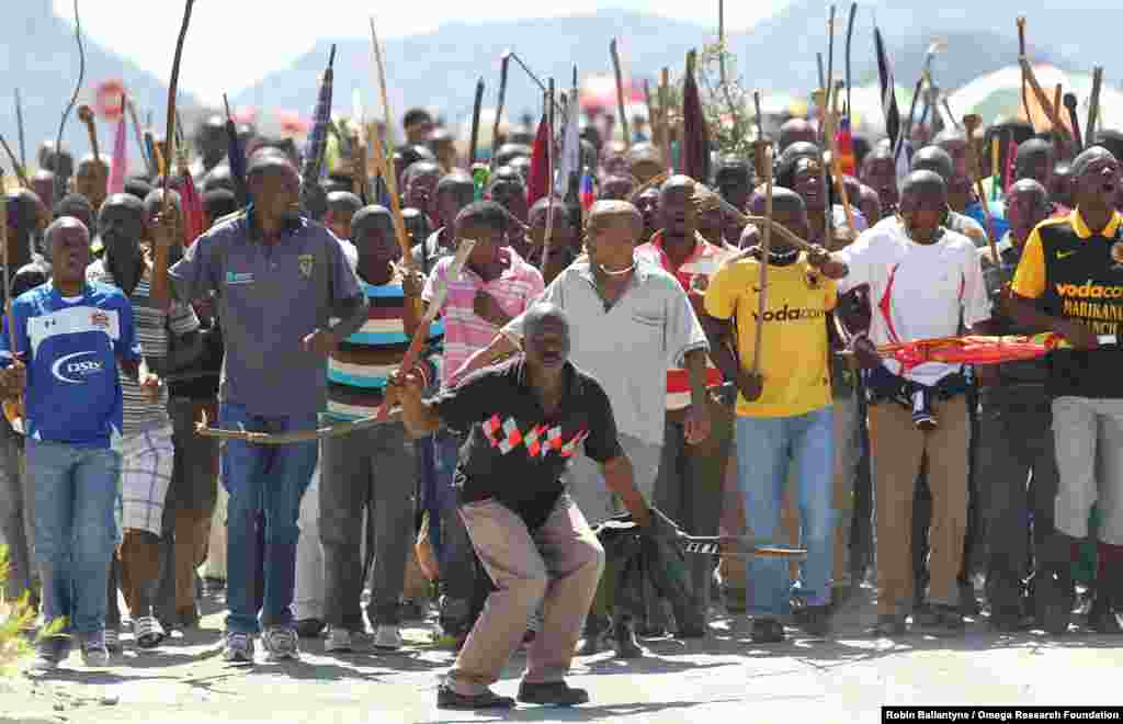 Miners sing and dance as they march to Lonmin Platinum Mine near Rustenburg, South Africa, Sept. 10, 2012, in an attempt to stop operations. 