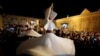 Para penari berputar menampilkan tarian tradisional Sufi selama bulan suci Ramadan di depan Masjid Umayyah, Damaskus, Suriah, 8 Juni 2018. (REUTERS / Omar Sanadiki)