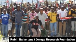 Miners sing and dance as they march to Lonmin Platinum Mine near Rustenburg, South Africa, Monday, Sept. 10, 2012, in an attempt to stop operations. 