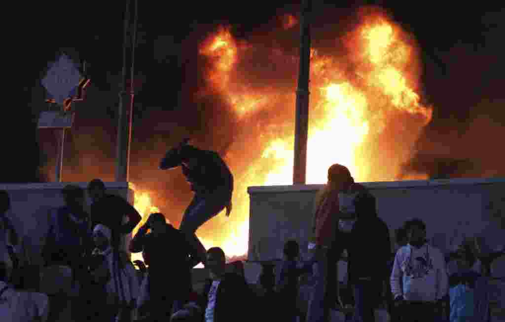 Seorang penggemar sepakbola melarikan diri dari kebakaran di Stadion Kairo di Port Said, Mesir, 1 Februari 2012 ( REUTERS).