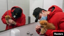 City resident Thomas Lim washes the face of his Pomeranian puppy named "Ohoh" at a public restroom sink, after the dog got dirty while out for exercise, during a lockdown to curb the spread of a coronavirus disease (COVID-19) outbreak in Sydney, Australia