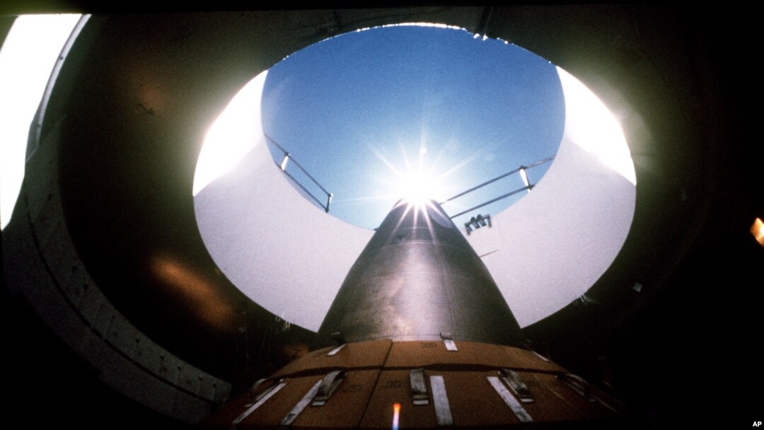 An LGM-118A Peacekeeper intercontinental ballistic missile points skyward from its position in a silo