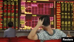 Investors track stock market information in Hiakou, Hianan China. China's stock market has lost 40 percent in value since June. Other markets around the world have had sharp gains and losses in recent weeks.