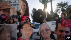 Relatives and supporters of Israeli hostages held by Hamas in Gaza hold photos of their loved ones during a protest calling for their return, in Tel Aviv, Israel, Jan. 8, 2025. 