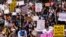 Demonstrators hold signs during a rally against anti-Asian hate crimes outside City Hall in Los Angeles, March 27, 2021. 