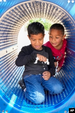 Manuel Rodriquez, left, and Dylan Guzman play in a park on May 18, 2024, in Aurora, Colorado.